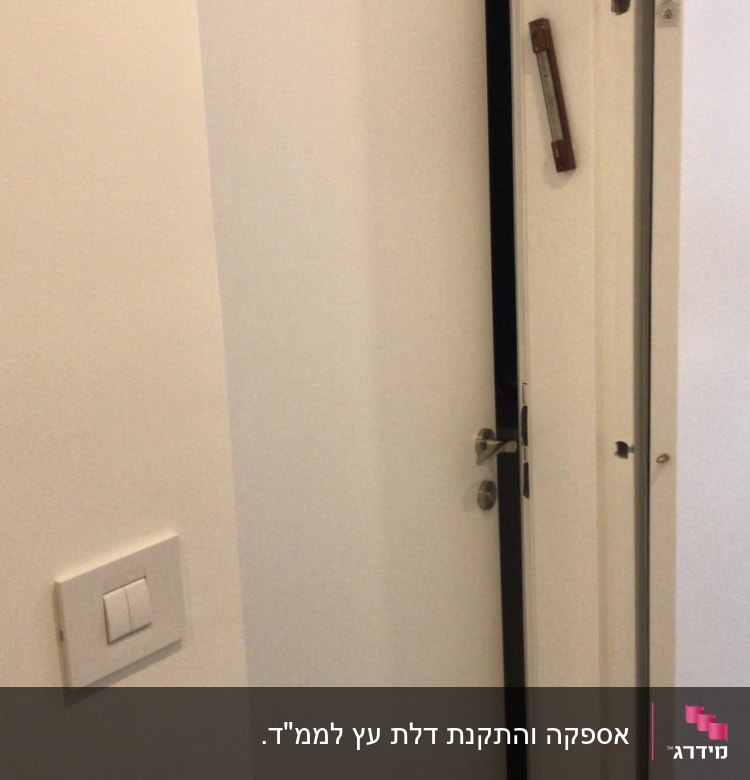 דלת לבנה פתוחה למחצה עם מזוזה על המשקוף